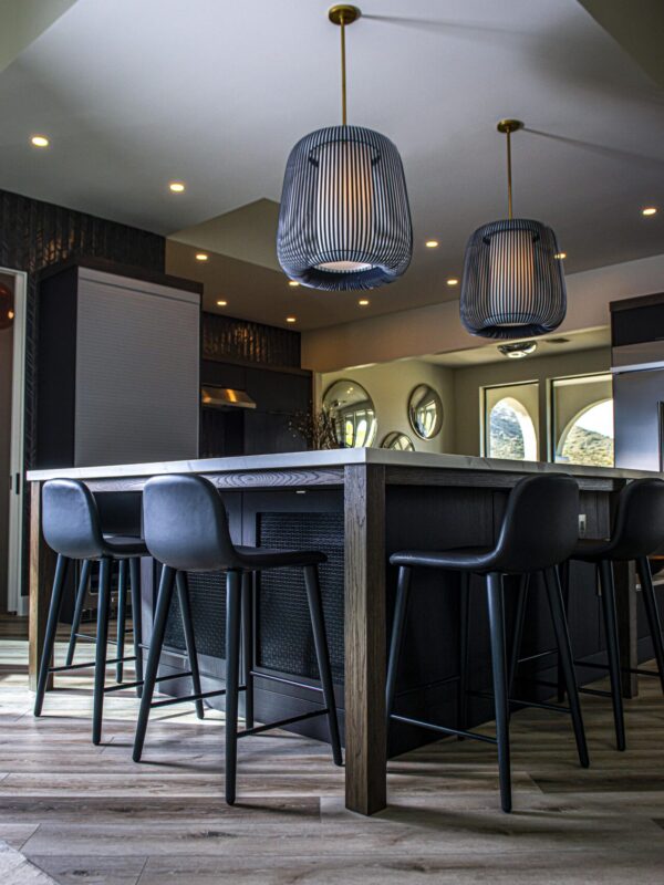 Home 3 modern kitchen island with dark wood base, bar seating, and woven pendant lights overhead